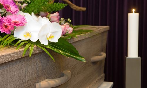 A coffin with flower arrangement in a morgue